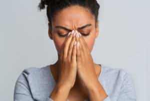 Young black woman touching her nose bridge